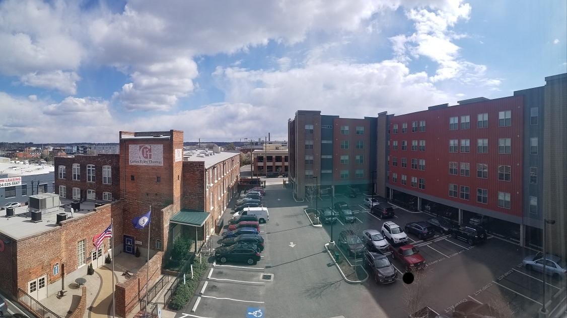 a view of a parking lot in a city with buildings